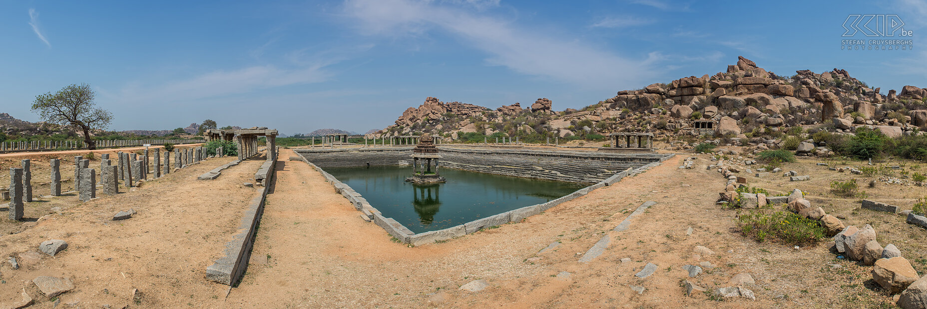 Hampi - Vittala watertank De iconische Vittala tempel ligt aan het einde van de Vittala Bazaar (=straat). Langs de weg staan er nog vele pilaren en enkele ruïnes van paviljoenen. In het midden van de weg ligt er een grote pushkarani (=watertank) met een paviljoentje in het midden. Stefan Cruysberghs